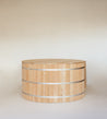 Cedar wood lid for a hot tub, featuring a smooth top and slatted sides with metal bands.