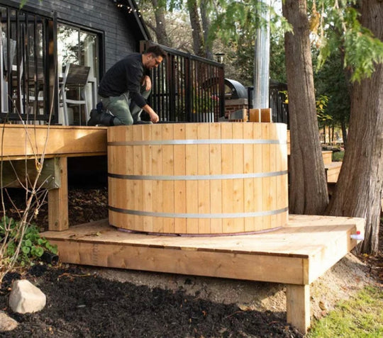 The man is setting hot tub near the house