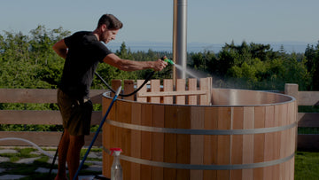 The man is cleaning wood fired hot tub