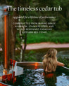 Wood fired hot tub on a deck overlooking a river and a person relaxing inside.