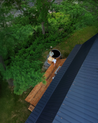 Aerial view of a wooden deck with a hybrid hot tub surrounded by trees