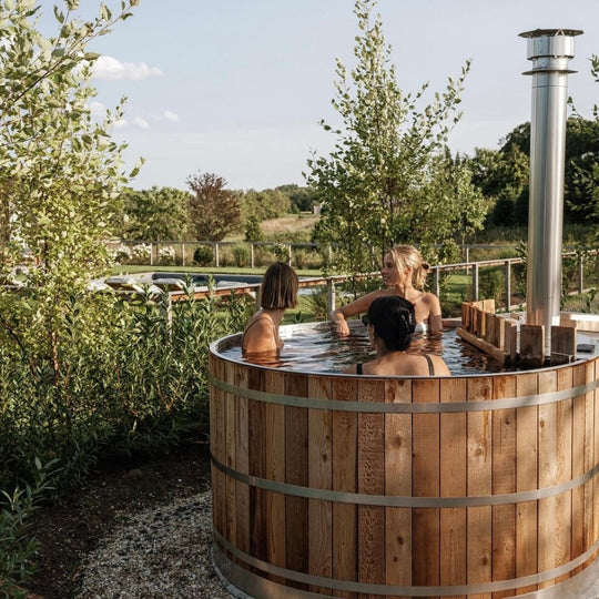 Wood fired cedar hot tub with 3 people soaking in it