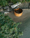 Wood fired cedar hot tub on the sandy beach filled with salt water