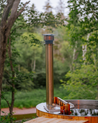 Wooden hot tub chimney sitting next to riverbed
