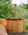 Wooden hot tub with a chimney in a natural setting