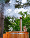 Wooden hot tub with steam rising in a forest setting