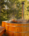 Cedar hot tub with steam rising in a forest setting