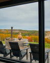 Person in a hot tub with a scenic view of trees and mountains.