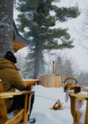 Person sitting by a hot tub in a snowy forest