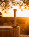 Wooden hot tub with a scenic sunset background