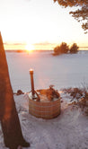 A steaming Wood Fired AlumiTub in the snow at sunset on the shore of Lake Superior
